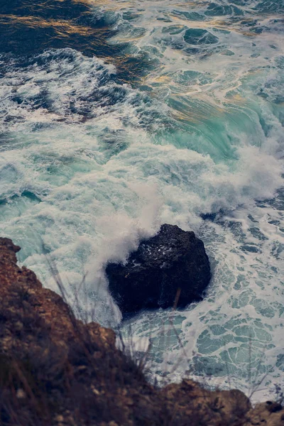 Las olas del mar chocan contra la costa rocosa —  Fotos de Stock