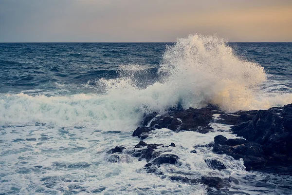 Des éclaboussures des vagues qui heurtent le rivage rocheux — Photo