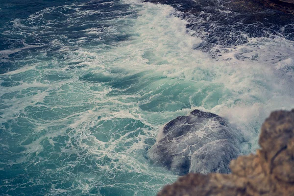 Las olas del mar chocan contra la costa rocosa —  Fotos de Stock