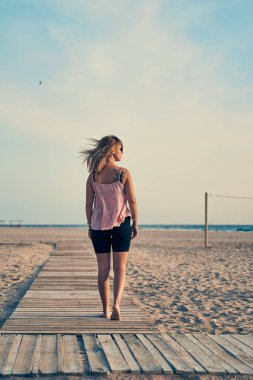 Deniz kenarında yürüyüş yapan bir kadın ve yaz tatili.