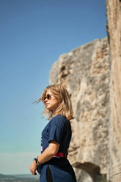 Jovem mulher ficar em uma rocha, olhando para a paisagem e apreciando a vista e ar fresco. — Fotografia de Stock