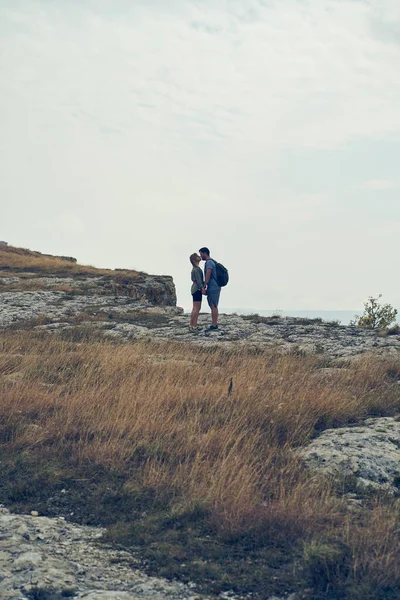 Par bo på stenar, vila, kyssar, njuta av utsikten och frisk luft. — Stockfoto