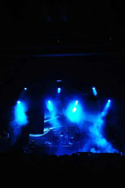 silhouettes of concert crowd in front of bright stage lights