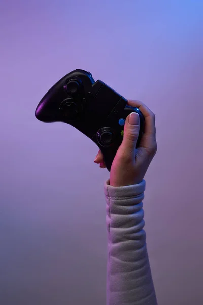 Mano con un joystick di gioco su sfondo viola. — Foto Stock