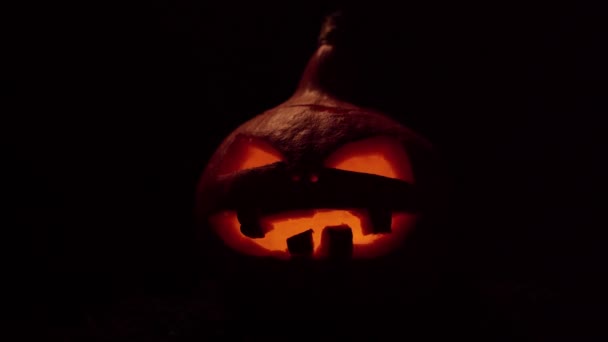 Calabaza con la boca y los ojos ardientes parpadeantes. Celebración Halloween. Video 4k. — Vídeos de Stock