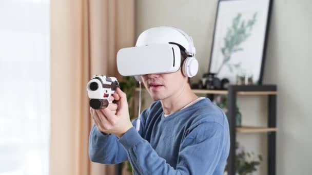 Homem está jogando jogo com realidade virtual headset e blaster. — Vídeo de Stock