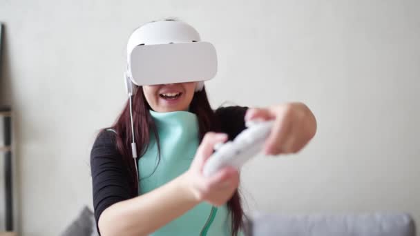 Женщина играет в игру с гарнитурой виртуальной реальности и джойстиком. — стоковое видео