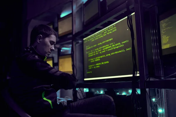 Hacker está trabajando con texto de escritura de computadora en la habitación oscura. — Foto de Stock