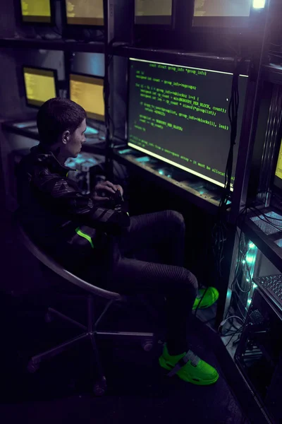 Hacker está trabajando con texto de escritura de computadora en la habitación oscura. — Foto de Stock