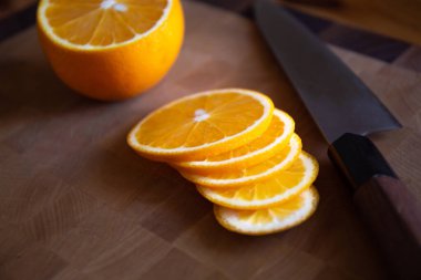 Şefin bıçağı ve portakal dilimleri kesme tahtasının üzerinde.