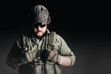 Zırhlı asker ve taktik koruma ekibi sisli siyah arka planda duruyor..