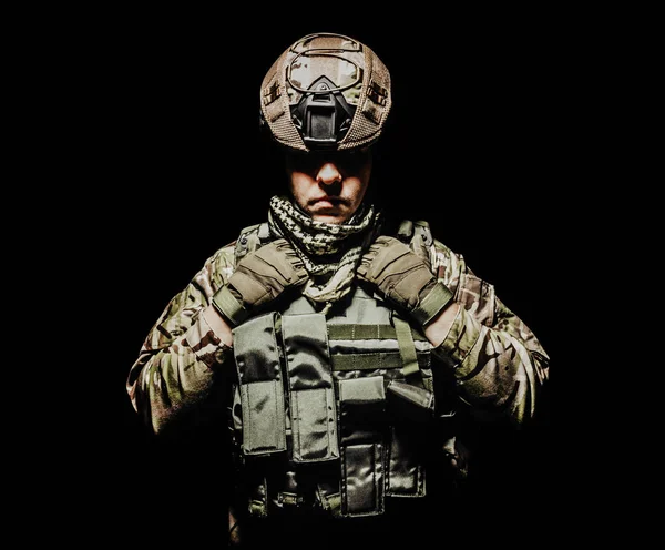 图为一名身穿盔甲背心 头戴头盔 装备齐全的士兵站在黑色背景下的照片 — 图库照片