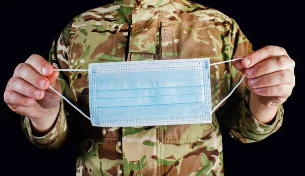 Zdjęcie Żołnierza Wojskowego Zakamuflowanym Mundurze Trzymającego Medyczną Maskę Ochronną Czarnym — Zdjęcie stockowe