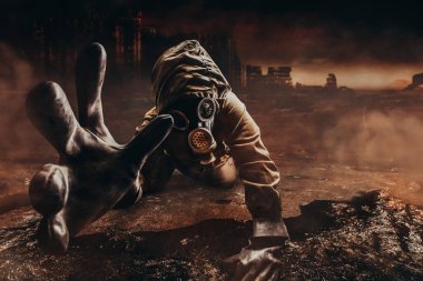 Ceketli ölmek üzere olan bir sapığın fotoğrafı ve zarar görmüş gaz maskeli eldivenli bir eldiven. Yıkılan vahiysel çorak şehir arka planında kameraya uzanan filtre..