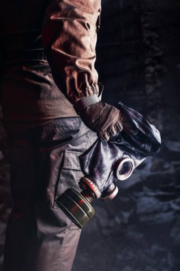 Eski solviet kauçuk gaz maskesi tutan eski ceket ve eldivenli tacizcinin fotoğrafı..