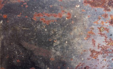 Paslı eski bir metal deseninin fotoğrafı. Gri tonlu, paslı ve çamurlu..