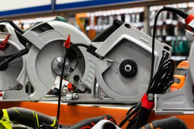 İnşaat malzemeleri mağazasının rafında duran elektrikli testerelerin fotoğrafı.