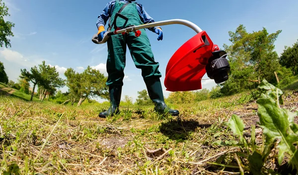 Foto Trabajador Overoles Verdes Botas Goma Usando Recortador Jardín Eléctrico — Foto de Stock