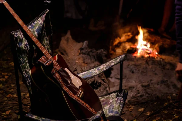 Arka planda alev alev yanan bir akustik gitar. Yaz kampı. Doğada rahatlama