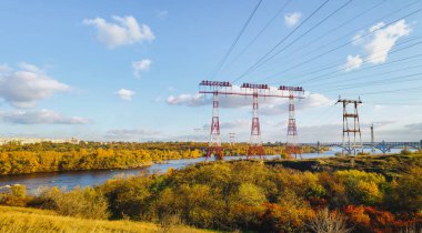 Yüksek voltaj direği, elektrik hattı, endüstriyel arka plan. Nehirdeki elektrik hatları