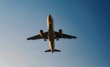 Açık gökyüzüne karşı geniş iniş takımları ile yer manzaralı bir uçağın ortası..