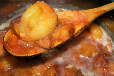 Reçel yapmak için tavada meyve güveci. Meyve reçelleri, ana koruyucu maddesi şeker ve bazen cam kavanozlarda depolanan ve sos olarak kullanılan asittir..