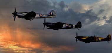 Duxford, Cambridgeshire, İngiltere, Eylül 2019. Üç ünlü dünya savaşı iki İngiliz Supermarine Spitire tek Merlin motoru alçak kanatlı tek koltuklu avcı uçağı..