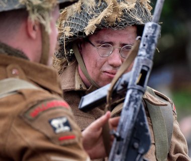İkinci Dünya Savaşı sahnesini canlandıran oyuncular duman, alev ve boş fişeklerle sahneleniyor. İngiliz askerleri.