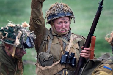 İkinci Dünya Savaşı sahnesini canlandıran oyuncular duman, alev ve boş fişeklerle sahneleniyor. İngiliz askerleri.