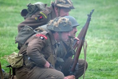 İkinci Dünya Savaşı sahnesini canlandıran oyuncular duman, alev ve boş fişeklerle sahneleniyor. İngiliz askerleri.