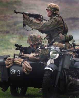 Yorkshire Savaş Deneyimi. Leeds, İngiltere, Ağustos 2021. İkinci dünya savaş üniforması giymiş aktörler savaş sahnelerinde patlamalar, duman, alev ve boş fişeklerle. Alman askerleri.