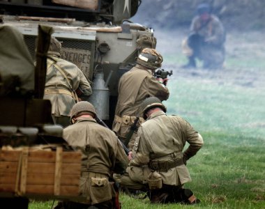 Yorkshire Savaş Deneyimi. Leeds, İngiltere, Ağustos 2021. İkinci dünya savaş üniforması giymiş aktörler savaş sahnelerinde patlamalar, duman, alev ve boş fişeklerle. Amerikan birlikleri tankın arkasında saklanıyor..