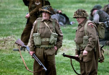 Yorkshire Savaş Deneyimi. Leeds, İngiltere, Ağustos 2021. İkinci dünya savaş üniforması giymiş aktörler savaş sahnelerinde patlamalar, duman, alev ve boş fişeklerle. İngiliz askerleri. 