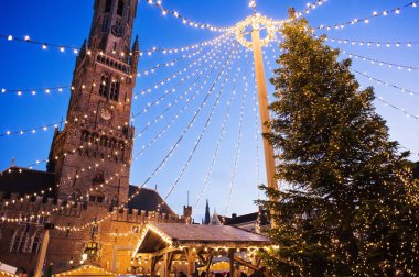 Avrupa, Bruges ve Belçika 'da geleneksel Noel pazarı. Süslü ağaç ve ışıklarla dolu ana kasaba meydanı. Noel Fuarı konsepti.