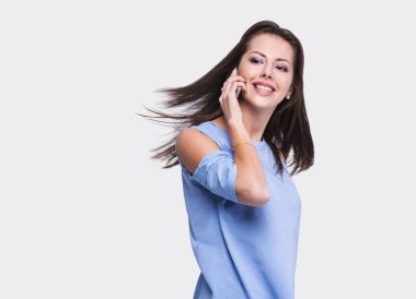 Genç bir kadın cep telefonuyla konuşuyor.