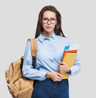 Kitaplarla poz veren güzel öğrenci portresi.