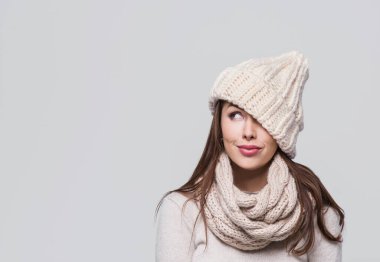 Güzel bir kadın beyaz arka planda izole edilmiş, kışın kalın kıyafetler giyen, gülümseyen bir kız.