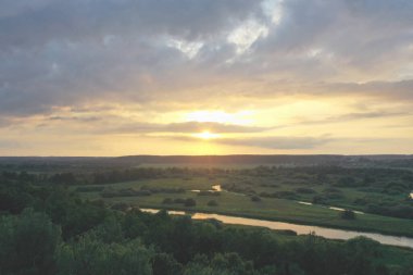 Nehir ve tarlanın üzerinde gün batımı