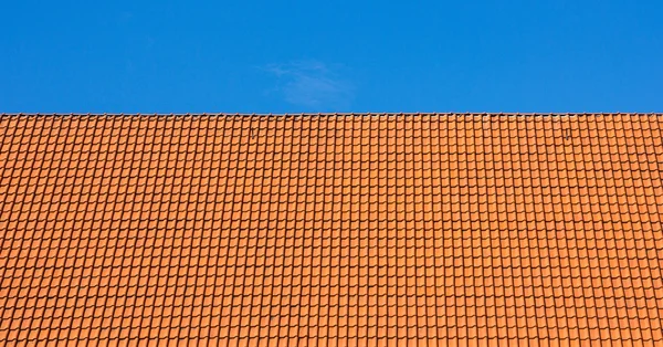 czerwony na dachu dachówki przeciw błękitne nieboKırmızı Çatı döşeme mavi gökyüzü