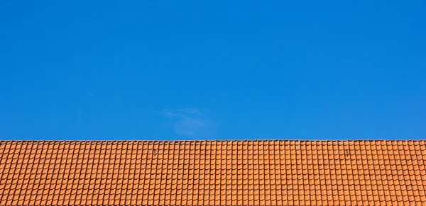 Toit rouge de tuiles contre le ciel bleu — Photo