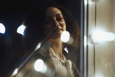 Genç, kıvırcık, Afro-Amerikan kızın portresi. Gece şehir ışıkları. Neon aydınlatması