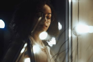 Genç, kıvırcık, Afro-Amerikan kızın portresi. Gece şehir ışıkları. Neon aydınlatması