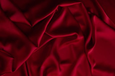 Kırmızı pürüzsüz kumaş dokuyu katlar. Lüks saten kumaş..