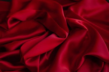Kırmızı pürüzsüz kumaş dokuyu katlar. Lüks saten kumaş..