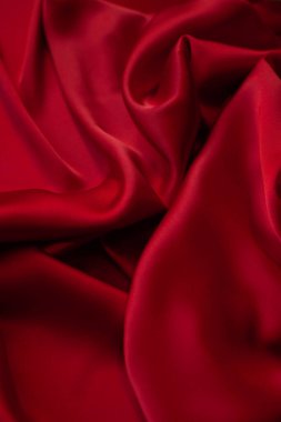 Kırmızı pürüzsüz kumaş dokuyu katlar. Lüks saten kumaş..
