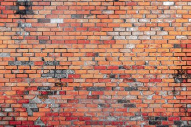 Yıpranmış kırmızı ve turuncu tuğlalı klasik tuğla duvar benzersiz bir kumaş sergiliyor..