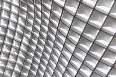 Geometrik tavan desenli modern mimari tasarım ve dinamik ışık oyunu.