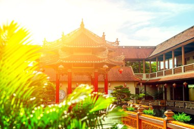 Geleneksel Asya tapınağı avlusunda fenerler ve güneş ışığı.