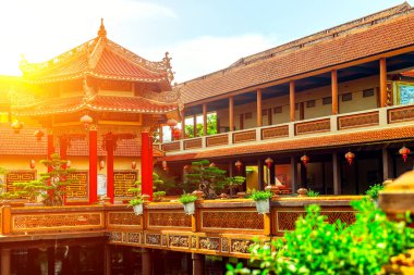 Geleneksel Asya tapınağı ve avlusu dekoratif mimarisi ve güneşli atmosferiyle.