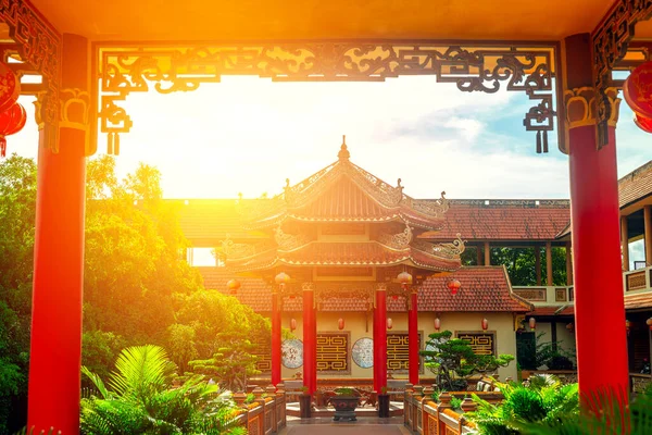 Bereketli bahçe ortamında güneş yanığı Asyalı mimarisi.